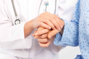Medical doctor holing senior patient's hands