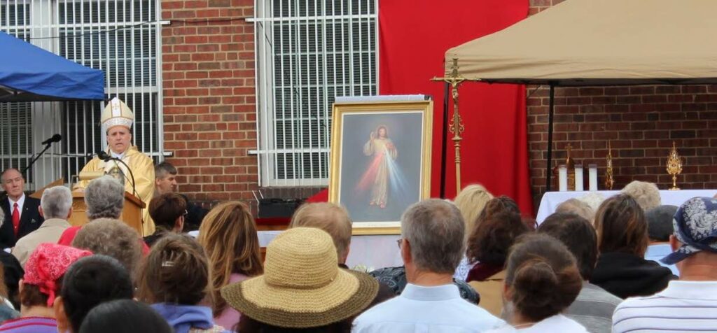 Archbishop Samuel Aquila speaks at St. Joseph Polish Church's first Divine Mercy Sunday celebration with relics of St. Faustina and St. John Paul II.