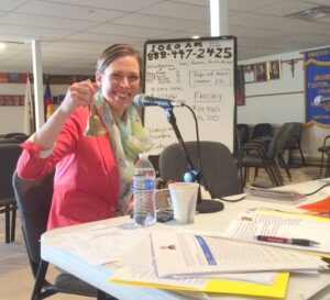 Karna Swanson, executive director of the Office of Communications, rings a bell during a KRCN pledge drive to support the Catholic radio station.