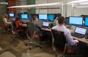 Staffers take messages from participants during the archbishop's interactive phone call at Broadnet company's offices.