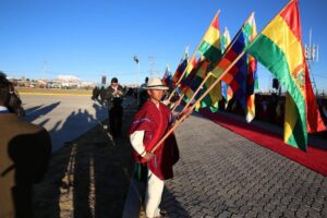 People holding flags while waiting for the pope to arrive at an airport in El Alto, Bolivia on July 8.