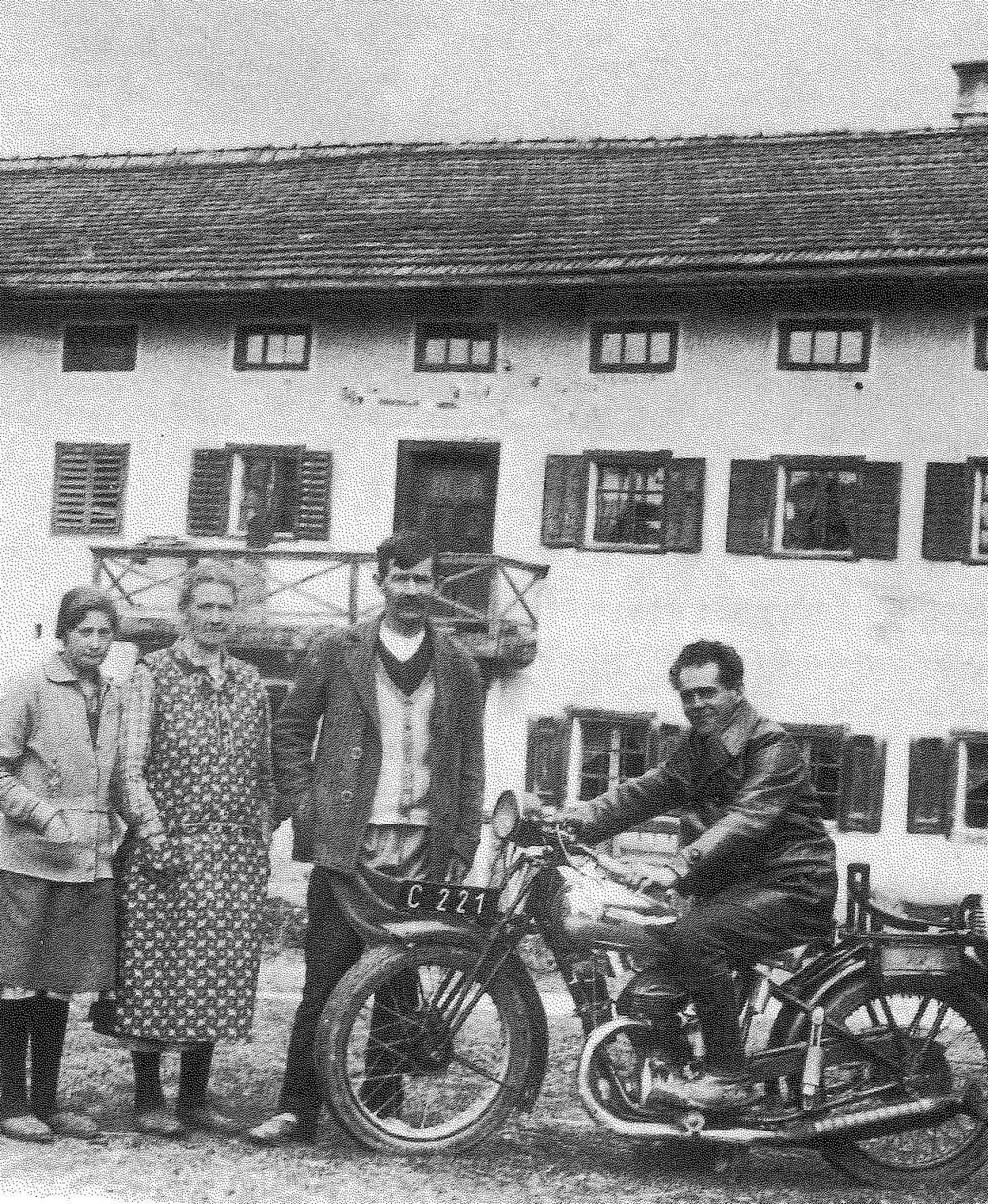 Franz Jagerstatter poses on his motorcycle. From right to left: Franz Jagerstatter; his stepfather, Heinrich Jagerstatter; his mother, Rosalia Jagerstatter; and Aloisia Sommerauer, Franz's cousin and foster sister. / Styria Verlag. Used with permission.