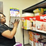 Shamika Ward stacks diapers at Gabriel House in Aurora on Sat. May 17th.