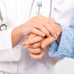 Medical doctor holing senior patient’s hands