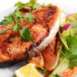 Tasty baked fish on plate close-up