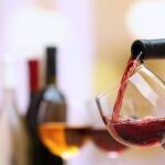 Red wine pouring into wine glass, close-up