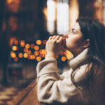a young pretty woman came to the temple to pray to God. The parishioner of the church sits on a bench with her hands folded for prayer and heartily prays. copy space